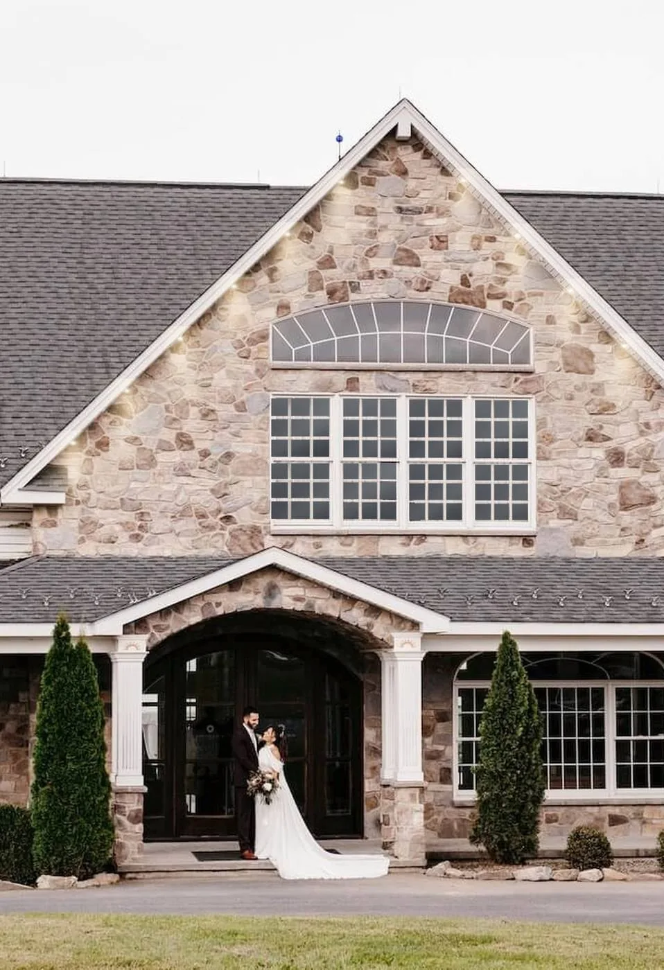 A couple beneath the mansion's stone entrance