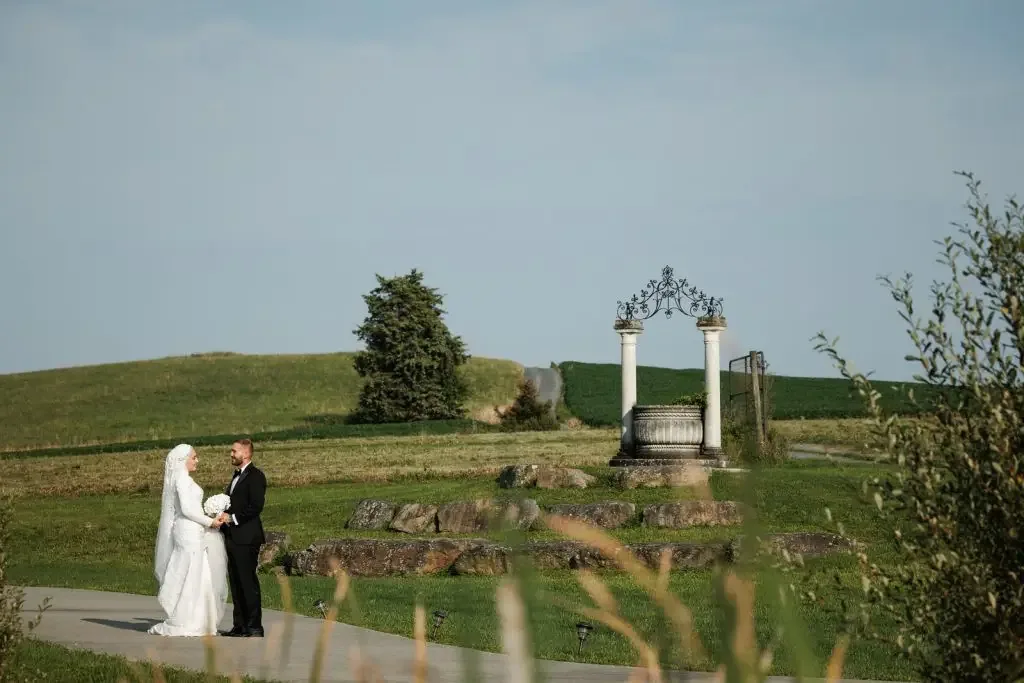 A couple at the stone wishing well with mountains behind