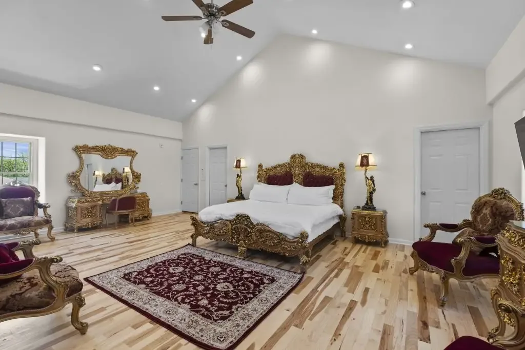 A guest suite with a carved bed and vaulted ceiling