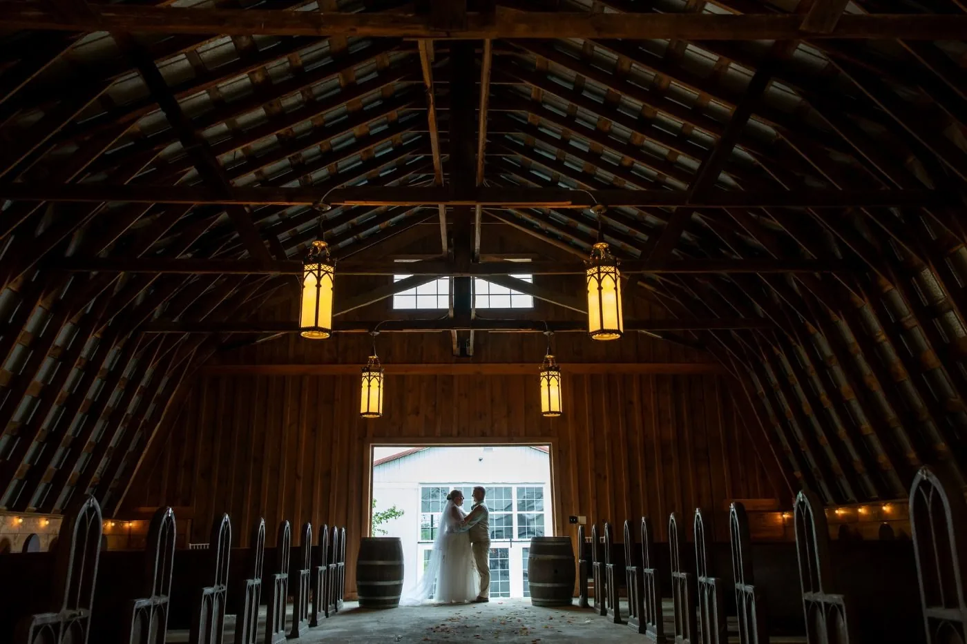 The restored barn, lanterns lit, set for a ceremony
