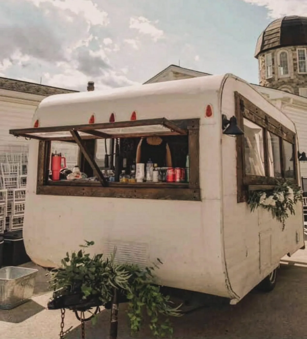 A vintage camper serving coffee beside the mansion